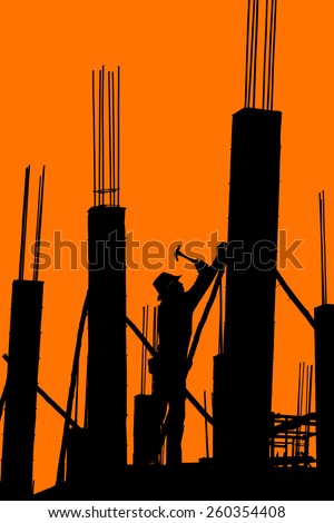 worker mounter assembling concrete formwork with hammer at construction site isolate on orange background