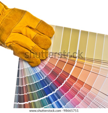 Worker\'s hand in a safety glove holding a color palette. Isolated on white.