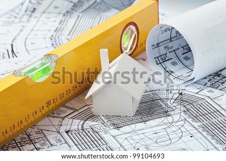 Small simple white model house on prints with a yellow leveler