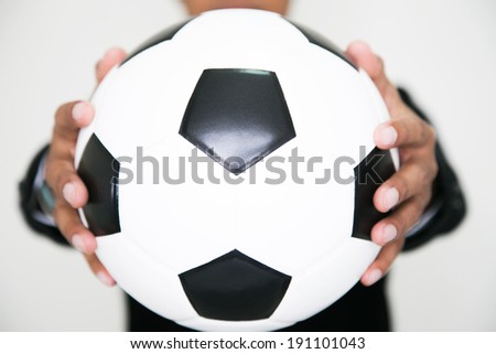 Football manager hold ball with his hands in studio