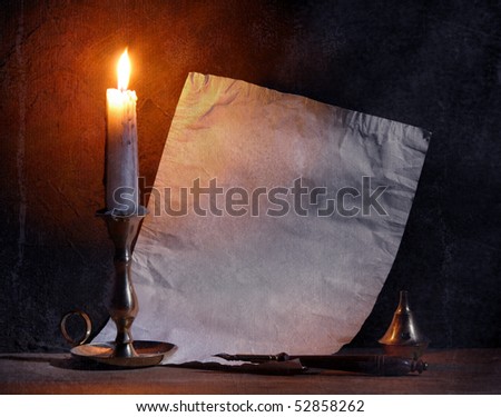 Old paper with a candle and a quill pen.