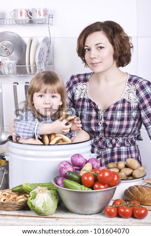 the little lovely girl in kitchen eats a bagel with mother