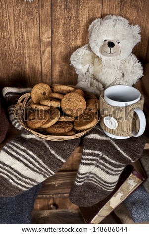 shelf with warm clothes, soft toy bear and cookies