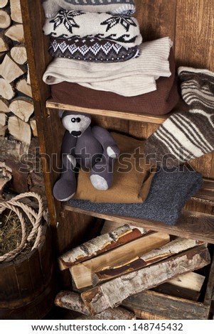 room with a cupboard with knitted clothes and books in a village house