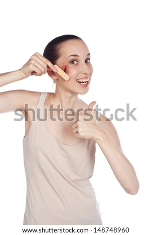 beautiful young woman joyfully glues the wound on his face plaster