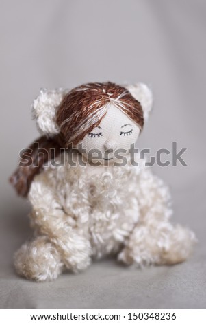 little cute doll sits in a suit teddy bear with eyes closed