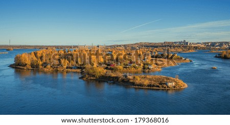 Autumn sunny island in the city of Irkutsk on the Angara River. View from the new bridge.