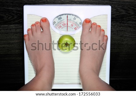 The young woman is weighed on scales