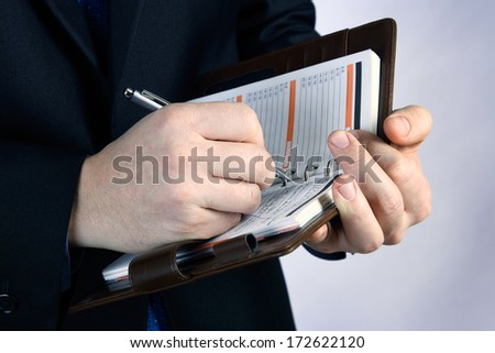 The young businessman writing on the notebook