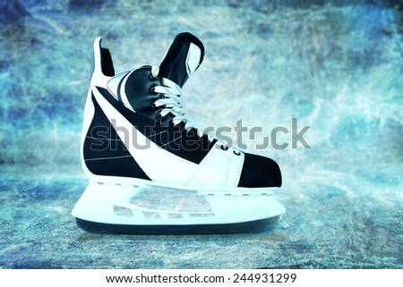 Man\'s hockey skates on ice background