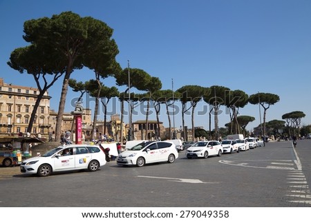 ROME, ITALY - APRIL 9, 2015: Piazza Venezia on April 9, 2015 in Rome, Italy. White taxi cars waiting for clients in front of Trajan's Forum.
