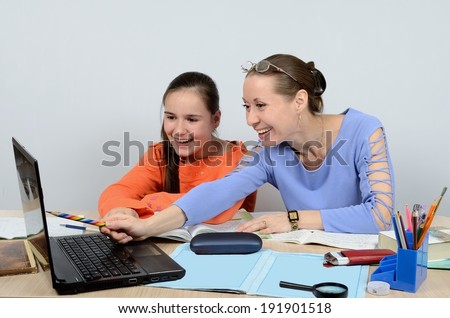 Woman teacher teaches the child is using the computer