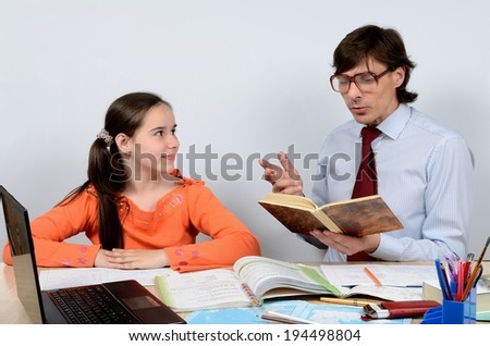 Teen schoolgirl listens attentively as the teacher reads a book