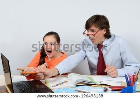 Male teacher fun teaches the schoolgirl to work on the computer