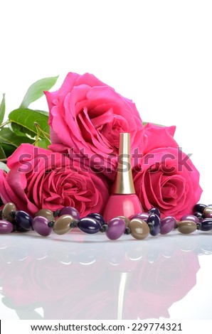 Cosmetics - nail polish, beads and three pink roses in a still life