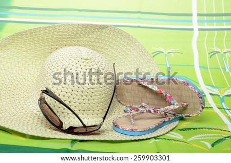 Beachfront set for summer vacation sandals, sunglasses, hat and pareo in still life