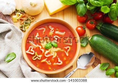 Bowl of pasta soup with heart shaped pasta and ingredients