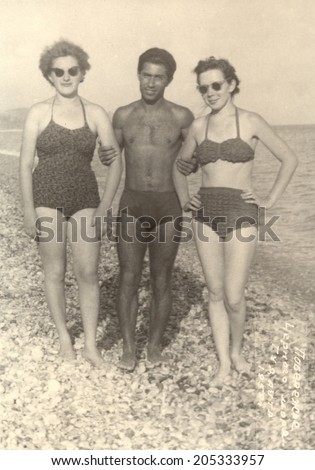 USSR - CIRCA 1959s : An antique photo shows man and two women in bathing suits on an Abkhazia beach