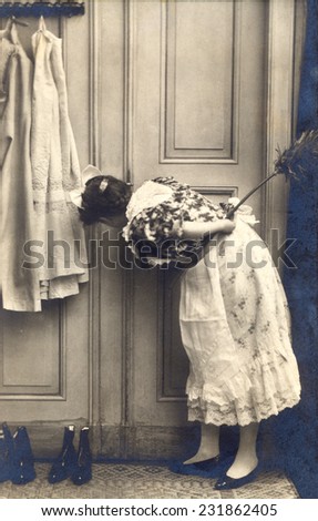 RUSSIA - CIRCA end of 19th - early 20th century: An antique Black & White photo of woman peeping through keyhole