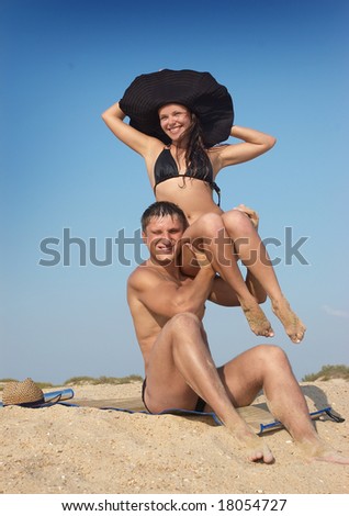The man holds the girl on hands and they laugh