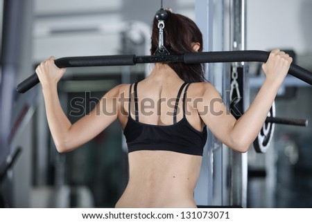 Woman at the gym doing exercises to strengthen the muscles of the back
