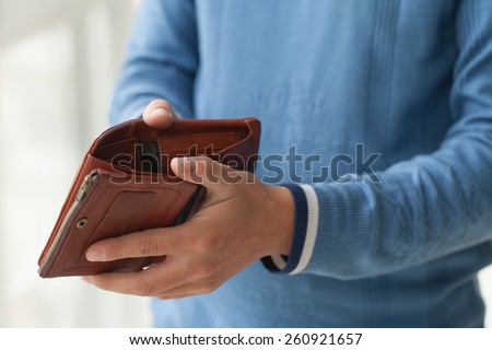 Open brown purse in male hands