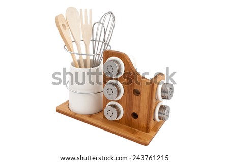 jars of spices and wooden cutlery on a wooden stand isolated on white background