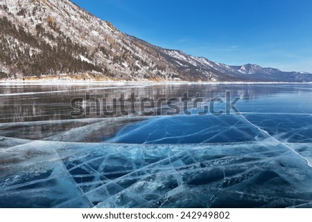 Baikal Lake in winter. Reflection of the mountains in a smooth ice surface