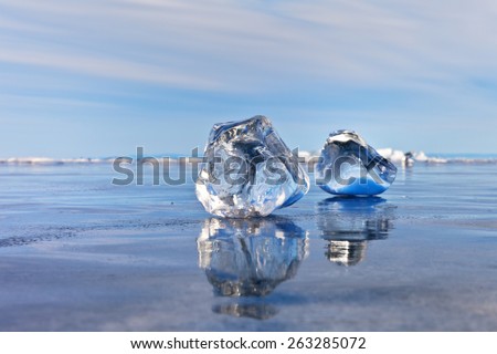 Baikal Lake. Transparent icicles on a smooth ice. Water treasures