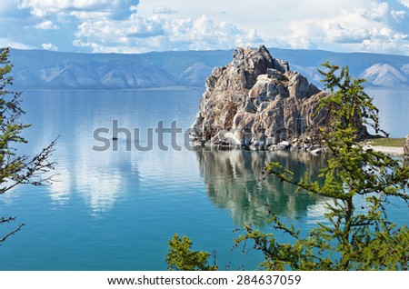 Baikal Lake in summer. Olkhon Island. Sundays Outdoors. Silhouettes of tourists sailing in a boat  near Shamanka Rock