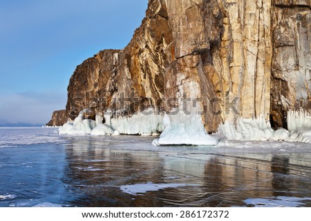 Winter landscape with beautiful coastal rocks on the frozen Lake Baikal in February evening