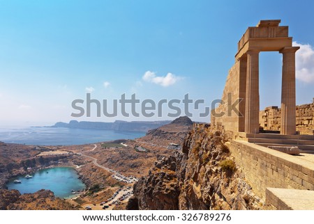 Greece. Rhodes. Acropolis of Lindos. Doric columns of the ancient Temple of Athena Lindia the IV century BC and the bay of St. Paul