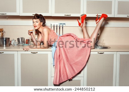 Girl in red shoes climbed on the kitchen table and eat cake.
