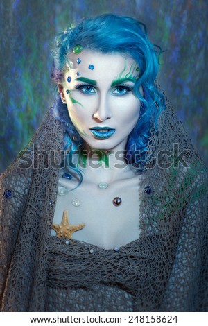 Portrait of a girl with blue hair and net on the body in a nautical theme.