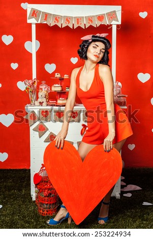 Girl with big red paper heart in hands.