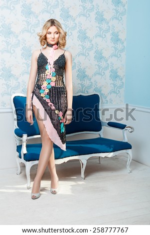 Girl standing in the room his eyes on the floor. Her beautiful crocheted dress with open legs, shoes on his feet.