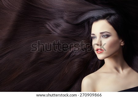 Portrait of a girl brunette closeup. She is lying on her long hair. Hair very much.
