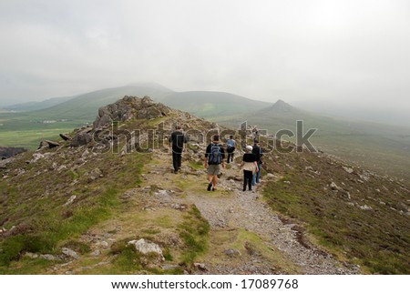 A group of people walking in Ireland on an overcast day.