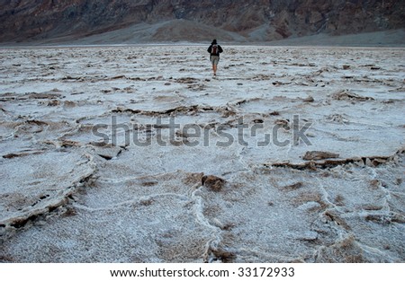 Single person walking on salt flats at Death Valley National Park.