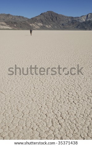 Single person walking on a dry lake bed in Death Valley National Park