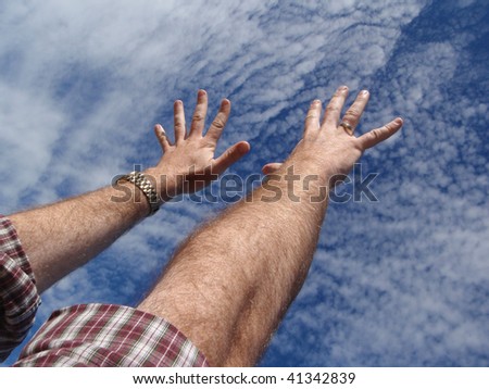 Pair of male arms and hands reaching towards the sky