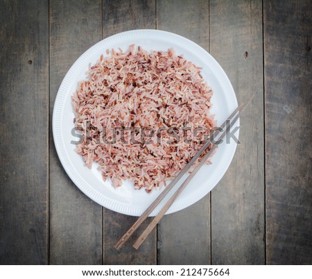 brown rice or unpolished rice in a plate with chopsticks