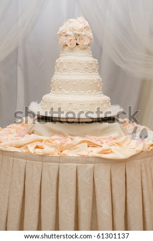 stock photo Beautiful ivory wedding cake with pink roses on a table