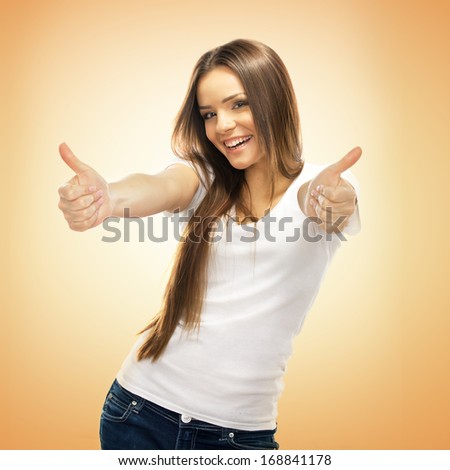 Happy smiling young woman with thumbs up gesture, on brown background
