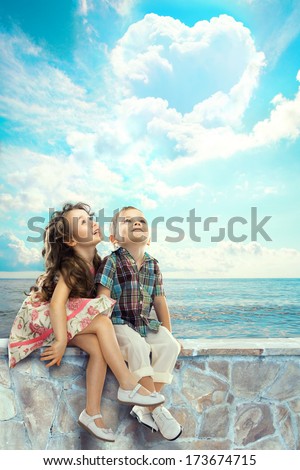 Happy Children Looking At Blue Sky With Heart Shaped Clouds. People, Happiness Concept.