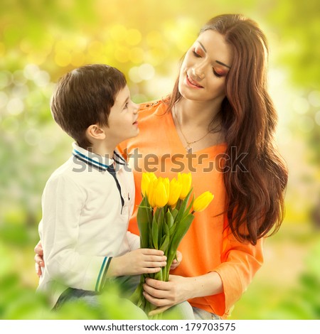 Son hugging his mother and gives her flowers. Spring, March 8, International Womens, Mothers day, family holiday