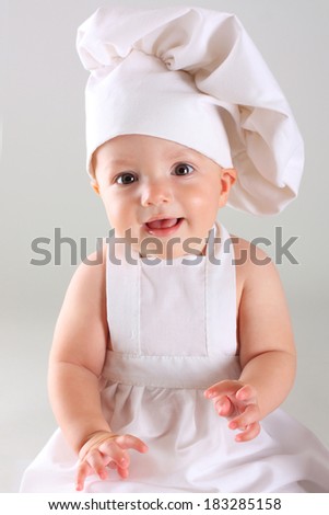 Happy cute little baby in a cook cap laughs