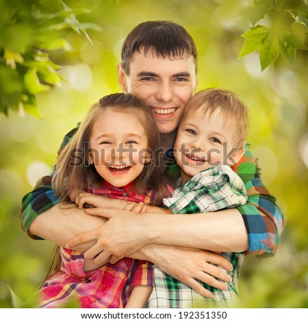 Portrait of joyful father hugging his son and daughter. Fathers day, family holiday, vacation