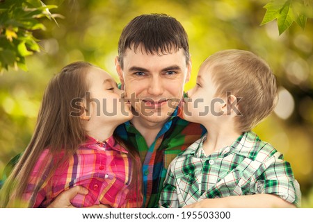 Happy daughter and son kissing their father. Fathers day, family holiday, vacation