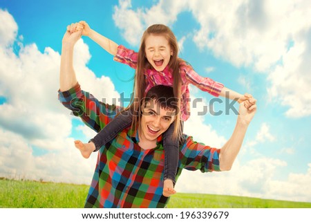 Joyful father with daughter on shoulders carefree and happy. Fathers day, family holiday, vacation